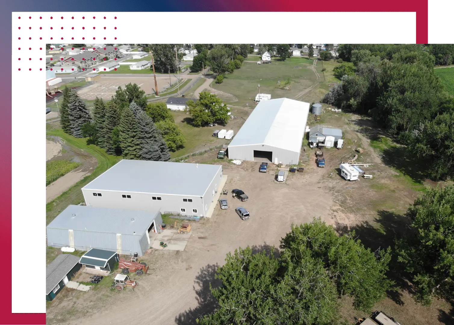 An aerial view of a building site with trees in the background.