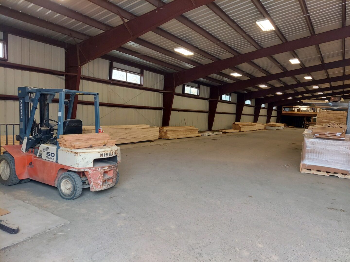 A forklift is parked in an empty warehouse.